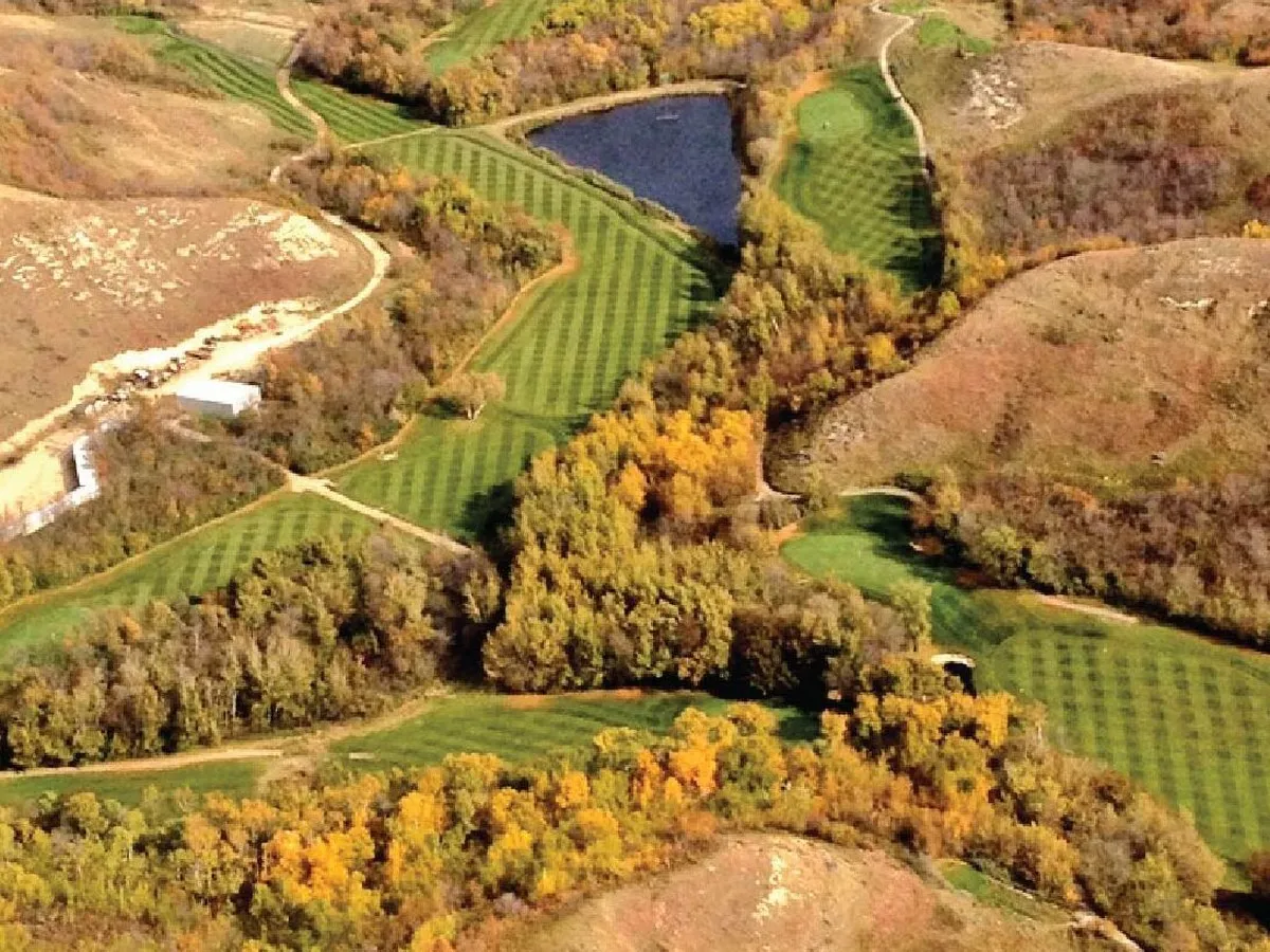 Aerial view of a Canadian golf course in autumn, fairways winding between trees and a pond
